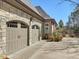 Two car attached garage with stone facade and brick accents at 601 Golfers Vw, Pittsboro, NC 27312
