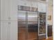 Modern kitchen featuring a stainless steel fridge, custom wine storage, and ample cabinet space at 601 Golfers Vw, Pittsboro, NC 27312