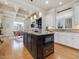 Open-concept kitchen with a dark island, granite countertops, and modern lighting at 601 Golfers Vw, Pittsboro, NC 27312