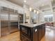 Kitchen with a large stainless steel refrigerator, wine fridge, central island, and open floor plan at 601 Golfers Vw, Pittsboro, NC 27312