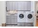 Laundry area with gray cabinets, granite countertop, sink, and washer/dryer at 601 Golfers Vw, Pittsboro, NC 27312
