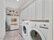 Spacious laundry room featuring built-in cabinetry, shelving, and washer/dryer at 601 Golfers Vw, Pittsboro, NC 27312
