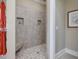 Walk-in shower featuring tiled walls, mosaic floor, and built-in niches at 601 Golfers Vw, Pittsboro, NC 27312