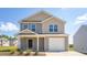 Charming two-story home with a one-car garage and manicured lawn against a bright blue sky at 6048 Sodium St, Raleigh, NC 27610
