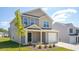 Charming two-story home with a one-car garage and manicured lawn against a bright blue sky at 6048 Sodium St, Raleigh, NC 27610
