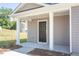 Inviting covered front porch with white pillars and a dark wood front door at 6048 Sodium St, Raleigh, NC 27610