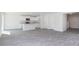 Open-concept living space with modern wood floors adjacent to the bright, white kitchen at 6048 Sodium St, Raleigh, NC 27610
