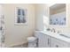 Bright bathroom featuring a marble floor, a vanity with a white countertop, and a window view at 6800 Chamonix Pl, Raleigh, NC 27613