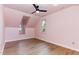 This bedroom features a sloped ceiling, wood floors, and two windows that provide natural light at 6800 Chamonix Pl, Raleigh, NC 27613