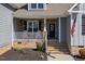 Home featuring a welcoming front porch with stone accents and neutral gray vinyl siding at 706 Mount Ranier Dr, Mebane, NC 27302