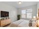 Cozy bedroom with a dresser, windows, and natural wood decor at 7201 Spanglers Spring Way, Raleigh, NC 27610