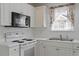 Close-up on kitchen appliances, including white cabinets, microwave, and stainless steel sink at 7201 Spanglers Spring Way, Raleigh, NC 27610