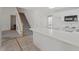 Kitchen featuring white cabinets, a breakfast bar, and a staircase leading upstairs at 7201 Spanglers Spring Way, Raleigh, NC 27610