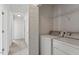Laundry room with a washer, dryer, wire shelving, and a hallway leading to other rooms at 7201 Spanglers Spring Way, Raleigh, NC 27610