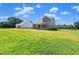View of the home's rear featuring a screened porch and a spacious, grassy backyard at 9004 Penny Rd, Raleigh, NC 27606