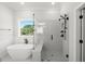 Bathroom featuring a modern soaking tub, wainscoting detail, and glass enclosed walk-in shower with bench seating at 9004 Penny Rd, Raleigh, NC 27606