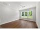 Bright bedroom featuring hardwood floors, three windows with natural light and neutral walls and trim at 9004 Penny Rd, Raleigh, NC 27606