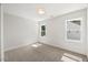 An empty bedroom with neutral carpet, two windows, and fresh white paint throughout at 9004 Penny Rd, Raleigh, NC 27606