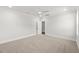 Bright bedroom with plush carpet, neutral paint, and ceiling fan; bedroom opens to hall and private bathroom at 9004 Penny Rd, Raleigh, NC 27606