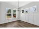 Bright dining room with large windows, a modern chandelier, and wainscoting on the walls at 9004 Penny Rd, Raleigh, NC 27606