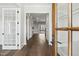 Inviting hallway with hardwood floors and white trim, leading to a bright living area with sliding doors at 9004 Penny Rd, Raleigh, NC 27606