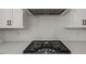 Modern kitchen featuring white backsplash, stainless steel gas range and white cabinets at 9004 Penny Rd, Raleigh, NC 27606