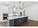 Modern kitchen with a large island, white cabinets, pendant lighting, and stainless steel appliances at 9004 Penny Rd, Raleigh, NC 27606
