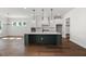 A modern kitchen with a large island, pendant lighting, and hardwood floors at 9004 Penny Rd, Raleigh, NC 27606