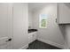 Bright laundry room with a sink, sleek cabinets, and a window with a view at 9004 Penny Rd, Raleigh, NC 27606