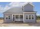 Back exterior view of home featuring covered porch and gray siding at 9004 Penny Rd, Raleigh, NC 27606