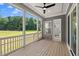Inviting screened porch with lots of natural light, ceiling fan, and an entrance to the home's interior at 9004 Penny Rd, Raleigh, NC 27606