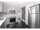 Modern kitchen with stainless steel appliances, gray cabinets, black tile flooring, and white countertops at 902 Phillip St, Garner, NC 27529