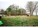 Expansive backyard with scattered trees, a brick fire pit, and a shed, offering ample outdoor space at 10166 Buffalo Rd, Clayton, NC 27527