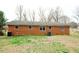 Rear exterior of a brick home showing an air conditioner, green grass, and trees at 10166 Buffalo Rd, Clayton, NC 27527
