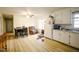Open kitchen and dining area with wood flooring, white cabinets, and bright natural light at 10166 Buffalo Rd, Clayton, NC 27527