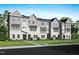 New construction townhomes displaying a sidewalk lined with landscaping and gray and white exterior at 1032 Zelkova Lane, Chapel Hill, NC 27517