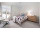 Bright bedroom with a large window, desk, wooden dresser, and a bed with floral patterned bedding at 104 Hampshire Pl, Chapel Hill, NC 27516