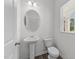 Bright bathroom with a pedestal sink, oval mirror, and wood-look vinyl flooring at 116 Oat Grain Ct, Clayton, NC 27520