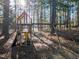 Backyard play area with swing set, climbing structure, and a surrounding wooded area at 138 Daneborg Rd, Durham, NC 27703