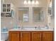 Bathroom with double sink vanity, two mirrors, and a white cabinet with open shelves at 138 Daneborg Rd, Durham, NC 27703