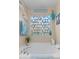 Bathroom with a tub, stained glass window, shells, and mermaid art at 138 Daneborg Rd, Durham, NC 27703