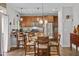 Well-lit kitchen with wooden cabinets, granite countertops, and a round dining table with seating at 138 Daneborg Rd, Durham, NC 27703