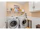 Bright laundry room with washer, dryer, shelves, and cabinets at 138 Daneborg Rd, Durham, NC 27703