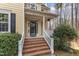 Front porch with brick steps and white railing on a charming yellow home at 151 Bennett Pl, Clayton, NC 27527