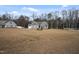 Single-story home with a spacious front yard, American flag, and lush tree line at 203 Mitchell Manor Dr, Angier, NC 27501
