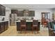 Well-lit kitchen featuring a center island with seating, dark cabinets, and stainless steel appliances, with an adjacent dining space at 203 Mitchell Manor Dr, Angier, NC 27501