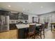 Bright, spacious kitchen with dark cabinets, stainless steel appliances, and a large island with bar seating at 203 Mitchell Manor Dr, Angier, NC 27501
