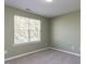 Neutral bedroom featuring carpet, light green walls, and a bright window at 205 Cedar Elm Rd, Durham, NC 27713