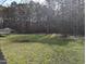 Backyard with trees and green space and the corner of a deck at 212 Davis Farm Dr, Selma, NC 27576