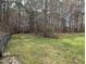 Fenced backyard with mature trees and green space at 212 Davis Farm Dr, Selma, NC 27576